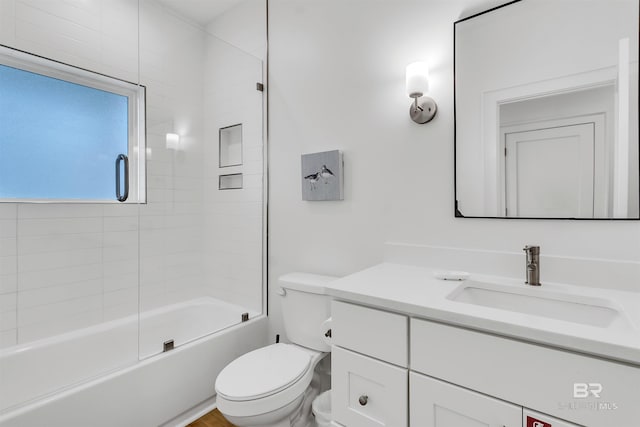 full bathroom with enclosed tub / shower combo, vanity, and toilet