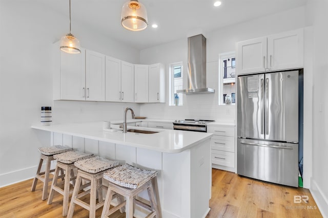 kitchen with range hood, white cabinets, a kitchen bar, kitchen peninsula, and stainless steel appliances