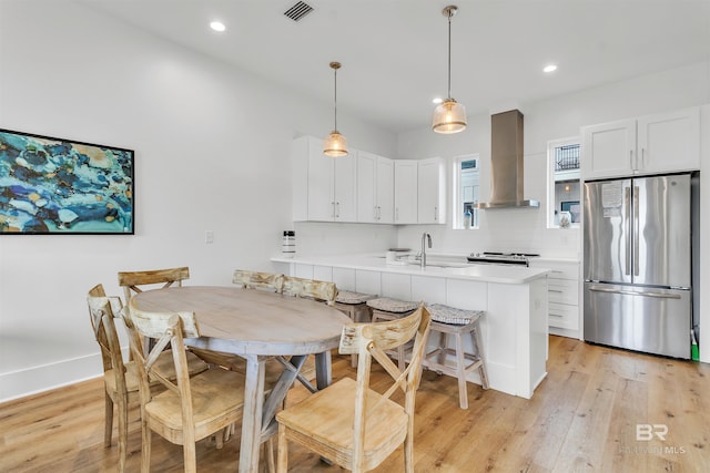 dining space with sink and light hardwood / wood-style flooring