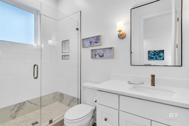 bathroom featuring vanity, an enclosed shower, and toilet