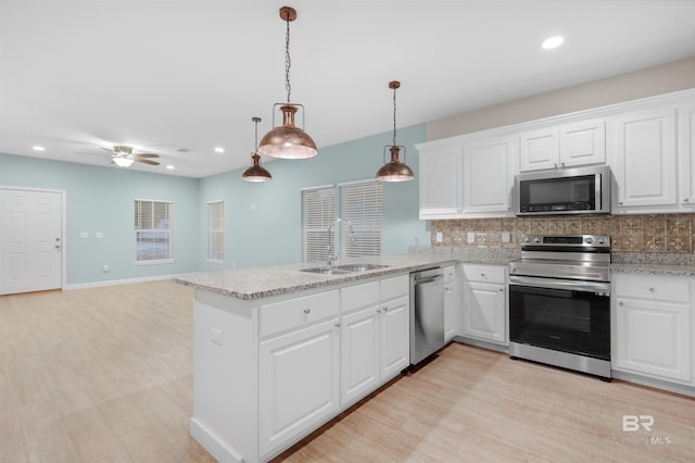 kitchen with stainless steel appliances, white cabinetry, and sink