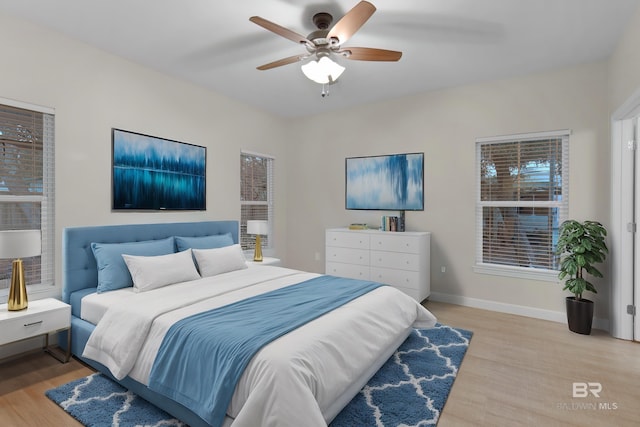 bedroom with ceiling fan and light wood-type flooring