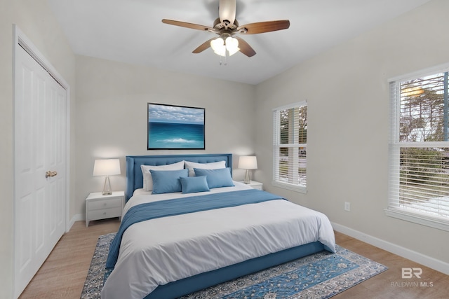 bedroom featuring ceiling fan, light hardwood / wood-style flooring, and a closet