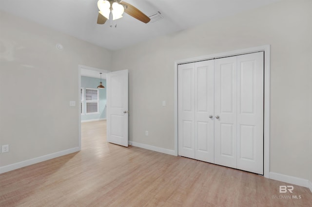 unfurnished bedroom with ceiling fan, light hardwood / wood-style floors, and a closet