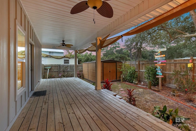 wooden terrace featuring ceiling fan and a storage shed