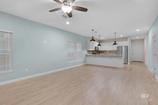 unfurnished living room with light hardwood / wood-style floors and ceiling fan