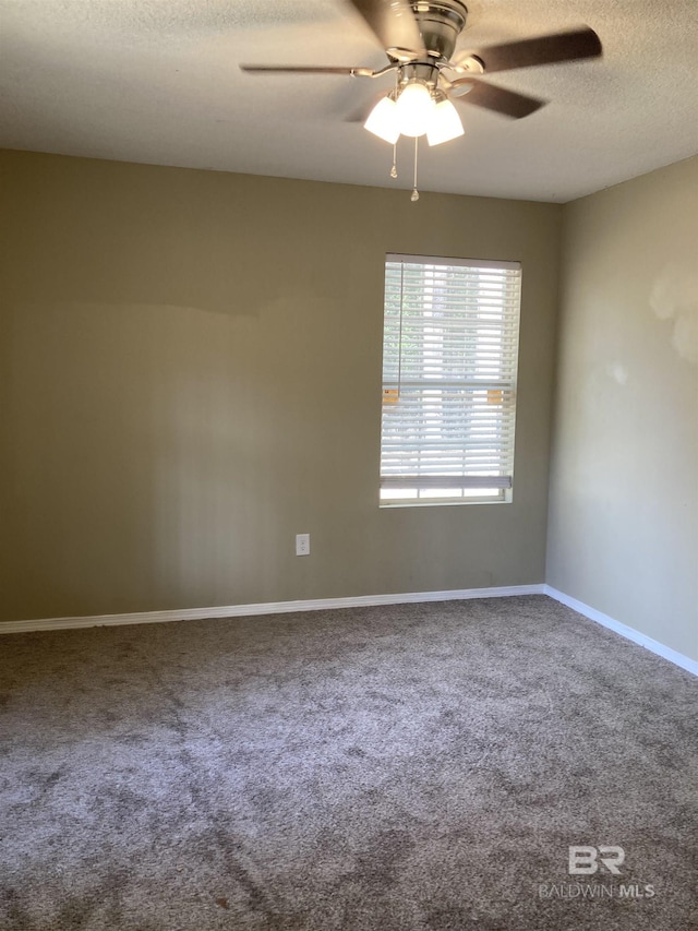 carpeted empty room featuring ceiling fan, baseboards, and a textured ceiling