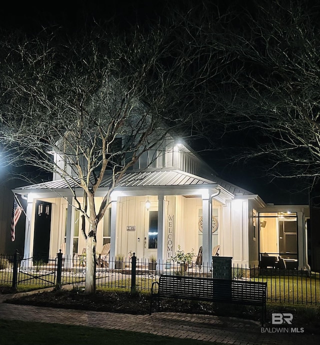 view of front of home featuring a fenced front yard, board and batten siding, and metal roof