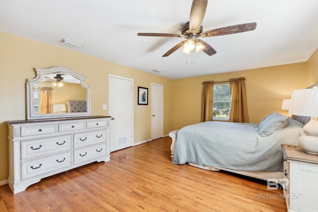 bedroom featuring light wood-style floors, visible vents, and baseboards