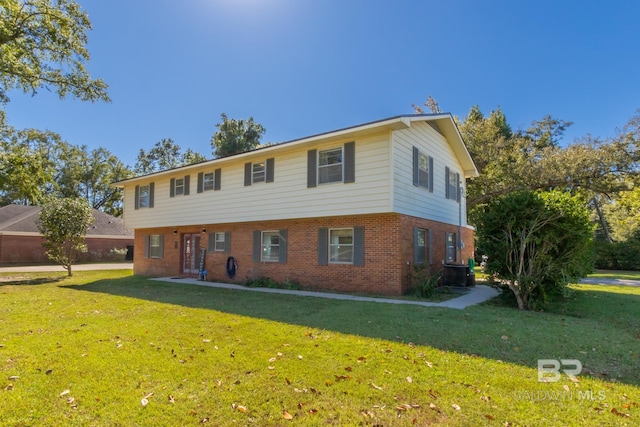 colonial home with central AC, brick siding, and a front yard