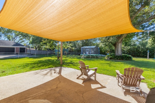 view of patio with a trampoline and a fenced backyard