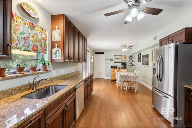 kitchen with stainless steel appliances, a ceiling fan, visible vents, and a sink