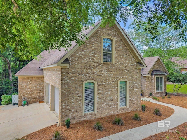 30230 Dolive Rdg, Daphne, AL 36527 - view of front of home featuring concrete driveway, brick siding, a garage, and roof with shingles