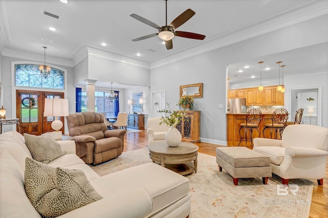 30230 Dolive Rdg, Daphne, AL 36527 - living room featuring a chandelier, decorative columns, light wood-style floors, ornamental molding, and a ceiling fan
