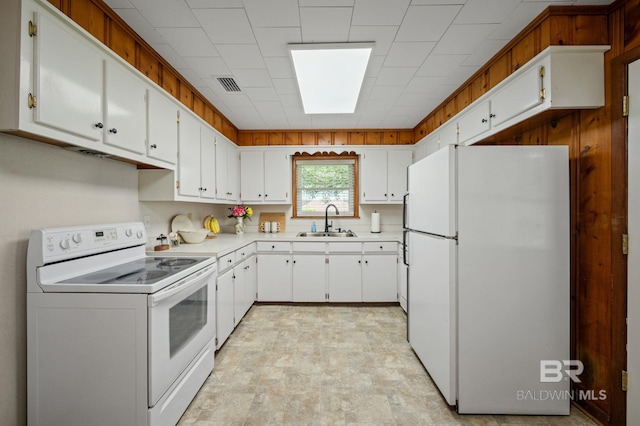 kitchen with white appliances, a sink, light countertops, and white cabinets