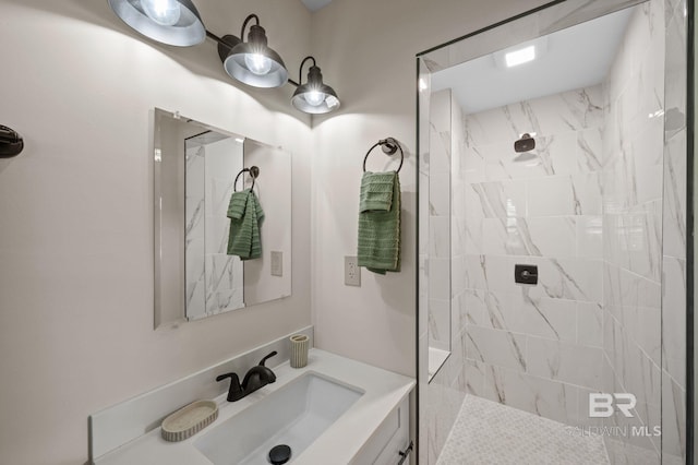 full bath featuring tiled shower and vanity