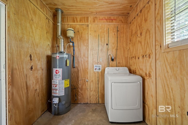 laundry area with washer / dryer, gas water heater, and wooden walls