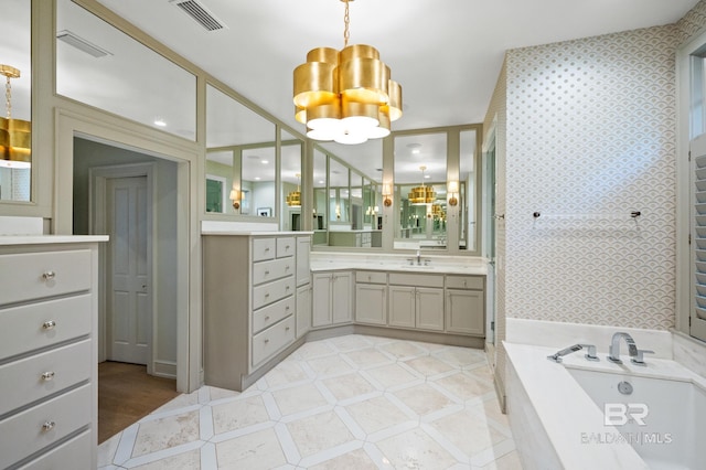 full bathroom featuring a garden tub, visible vents, a notable chandelier, and vanity