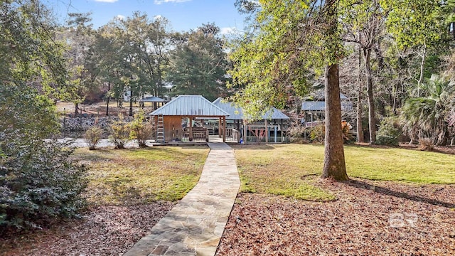 rear view of house featuring metal roof, a yard, and a gazebo