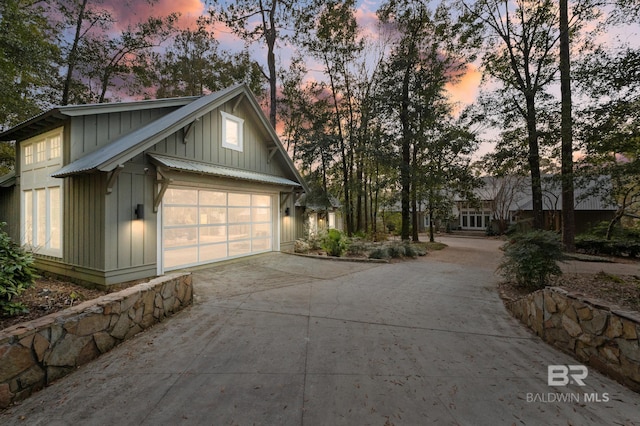 exterior space featuring board and batten siding and concrete driveway