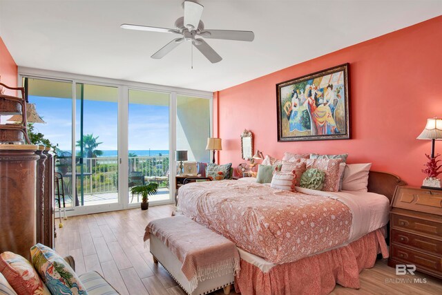 bedroom featuring light hardwood / wood-style floors, access to outside, expansive windows, and ceiling fan