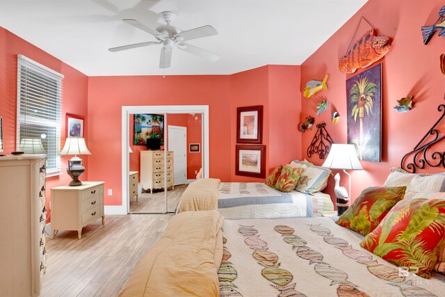 bedroom with light hardwood / wood-style flooring, a closet, and ceiling fan