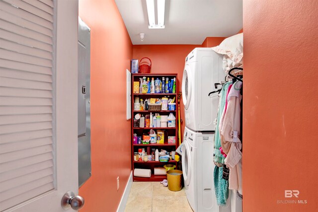 clothes washing area with stacked washing maching and dryer and light tile patterned floors