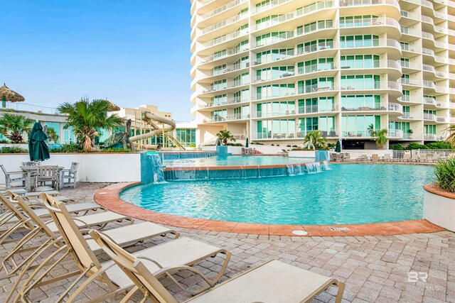 view of swimming pool featuring pool water feature and a patio