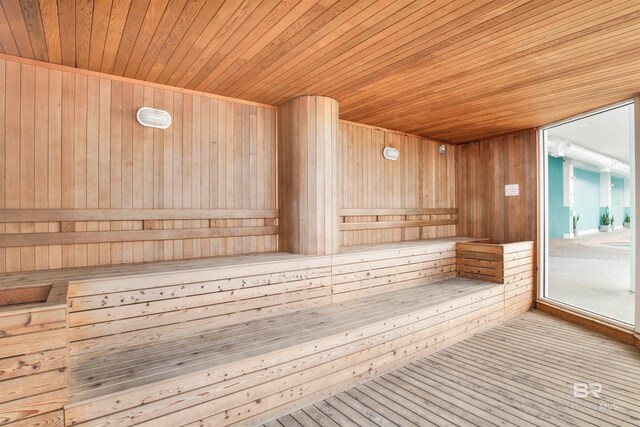 view of sauna with hardwood / wood-style floors, wood walls, and wooden ceiling