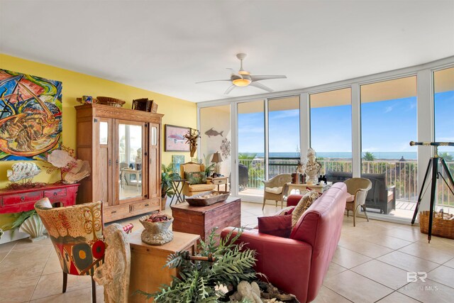 tiled living room featuring a water view, a wall of windows, plenty of natural light, and ceiling fan