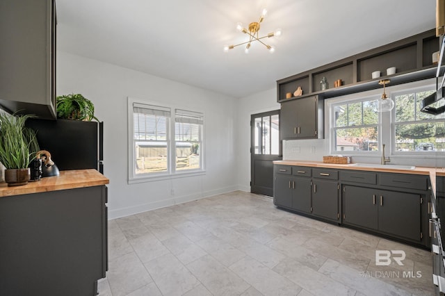 25121 State St, Elberta, AL 36530 - kitchen with black fridge, sink, a chandelier, gray cabinets, and butcher block counters