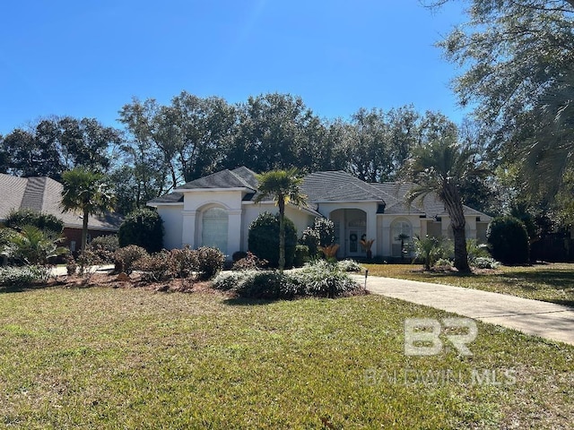 mediterranean / spanish-style house featuring driveway, stucco siding, and a front yard