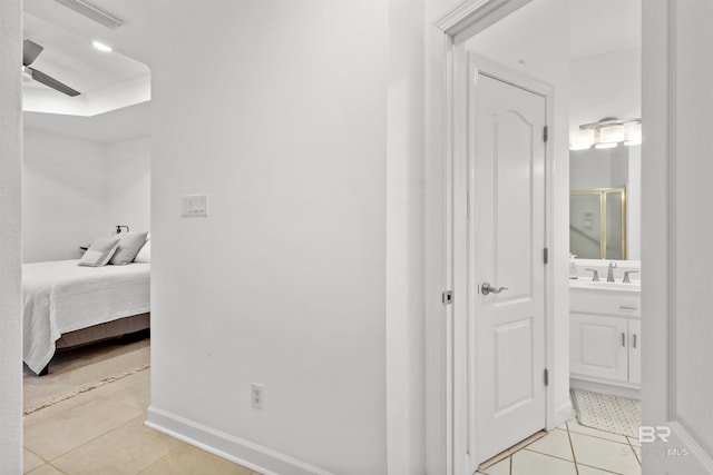 interior space featuring visible vents, a sink, baseboards, and light tile patterned flooring