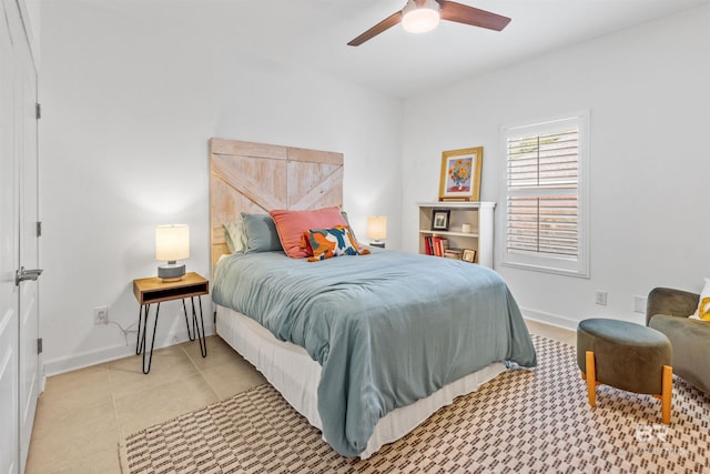 bedroom with light tile patterned flooring, a ceiling fan, and baseboards