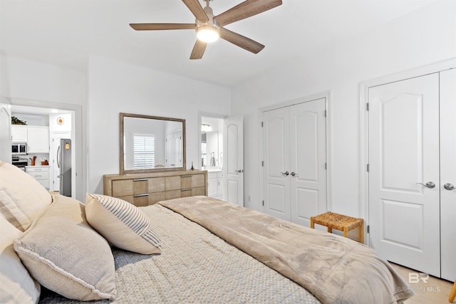 bedroom with ceiling fan, two closets, freestanding refrigerator, and ensuite bathroom