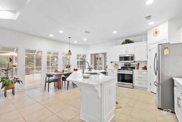 kitchen featuring appliances with stainless steel finishes, light countertops, a sink, and recessed lighting