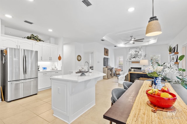 kitchen with visible vents, white cabinets, a raised ceiling, a ceiling fan, and freestanding refrigerator