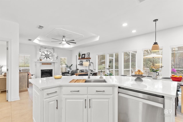 kitchen with a raised ceiling, visible vents, a sink, and stainless steel dishwasher