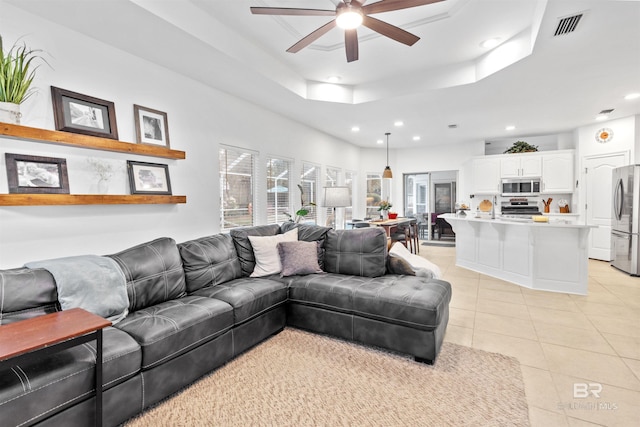 living area with recessed lighting, a raised ceiling, visible vents, light tile patterned flooring, and ceiling fan