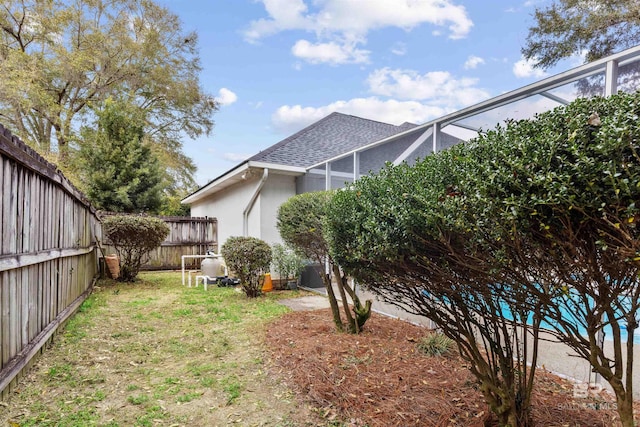 view of yard with a fenced backyard and a lanai