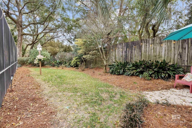 view of yard featuring glass enclosure and fence