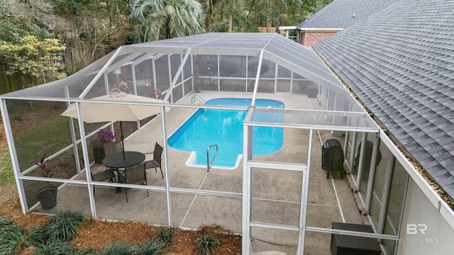 outdoor pool featuring a patio area and glass enclosure