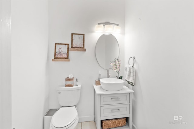 bathroom featuring toilet, tile patterned floors, vanity, and baseboards