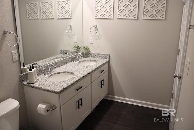 bathroom with hardwood / wood-style flooring, vanity, and toilet