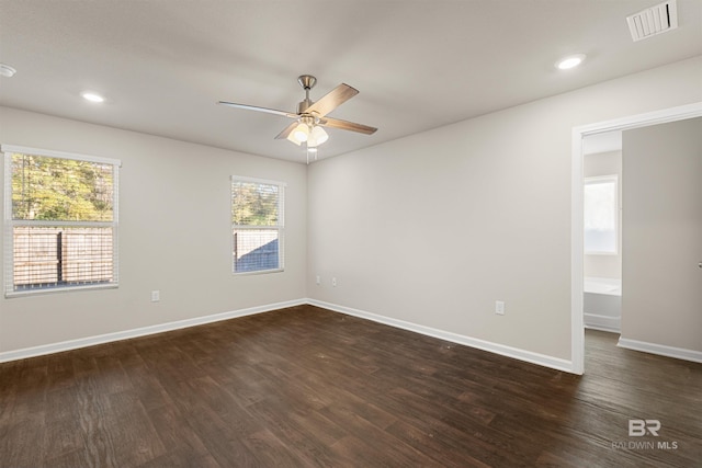 empty room featuring ceiling fan, dark hardwood / wood-style flooring, and a healthy amount of sunlight