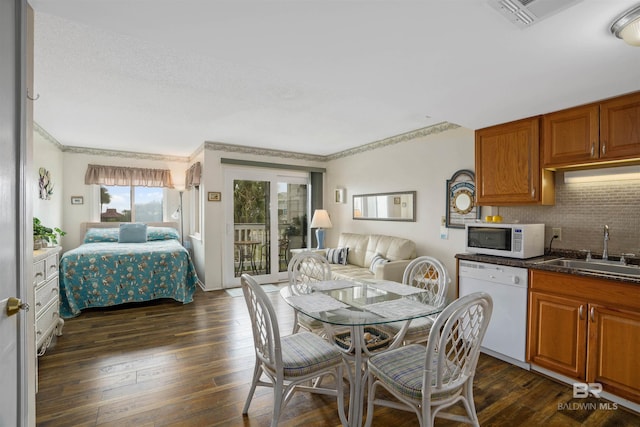 kitchen with decorative backsplash, sink, dark wood-type flooring, and white appliances