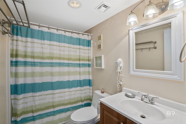 bathroom with curtained shower, vanity, and toilet