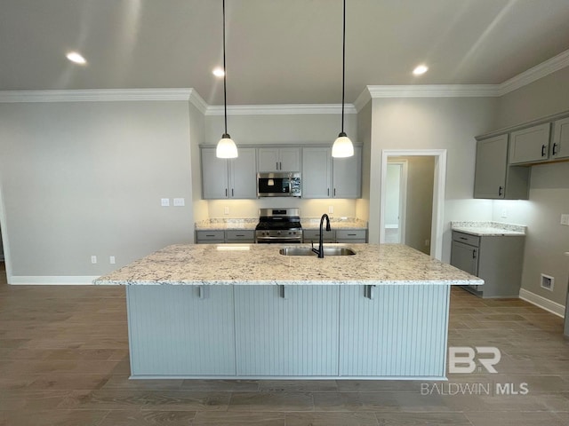 kitchen with gray cabinetry, light stone counters, sink, and stainless steel appliances