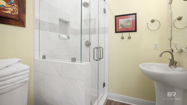 bathroom featuring sink and a shower with door