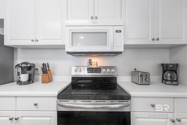 25360 Perdido Beach Blvd Unit 401, Orange Beach, AL 36561 - kitchen featuring electric stove, white microwave, white cabinetry, and light countertops